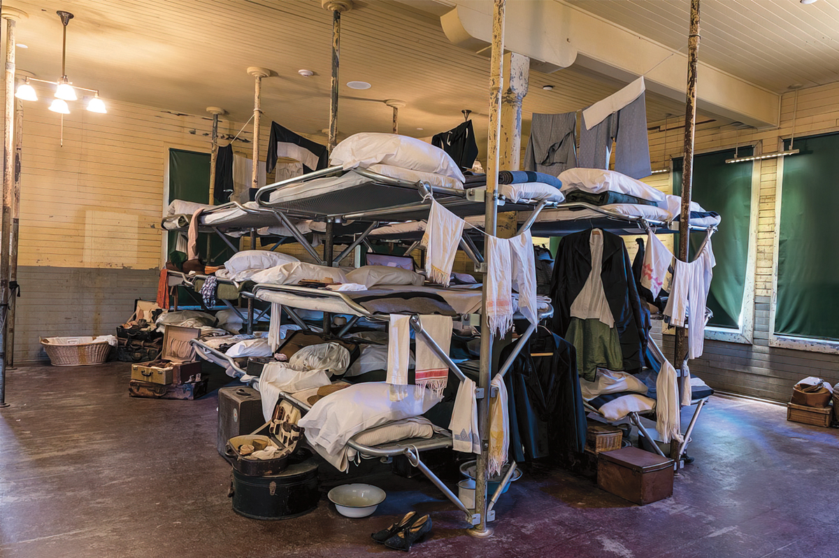 Bunk beds with three beds in each and personal items hanging off them