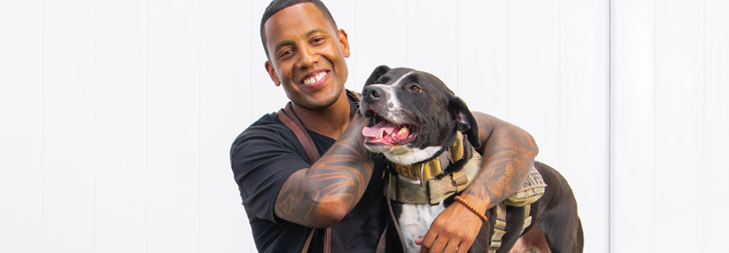 Image of a veteran posing with his service dog