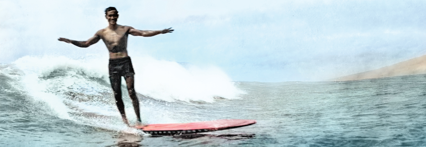 Photo of a surfer smiling while riding a wave