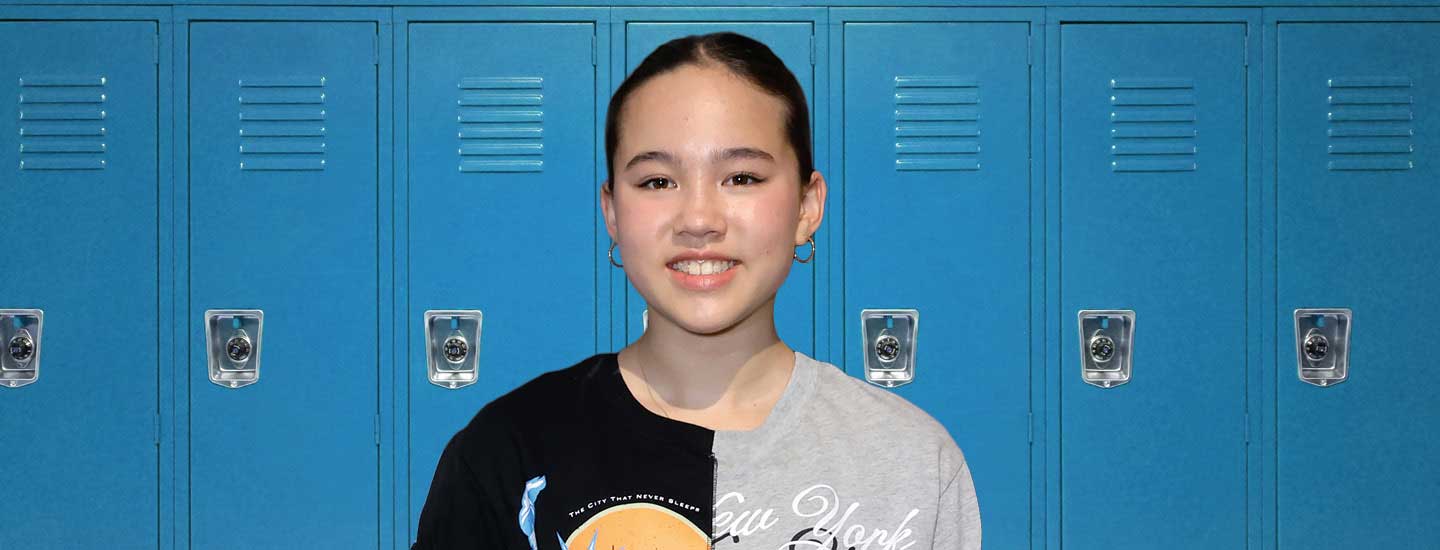 Photo of a teen standing in front of lockers