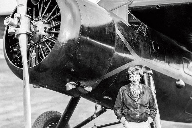 Amelia Earhart next to her airplane