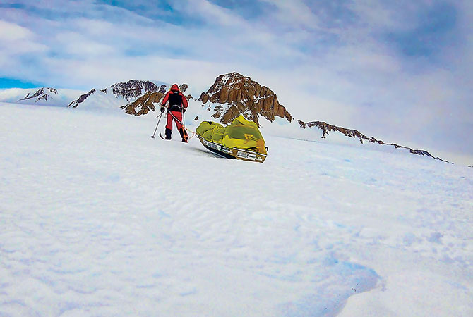 A person dragging a sled through the snow