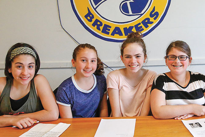 Four girls sitting at a table smiling